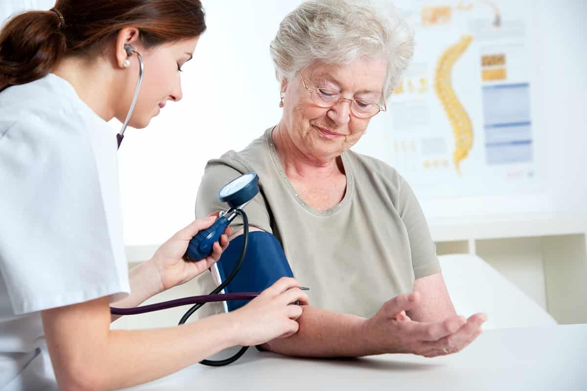 Medical assistant measuring blood pressure